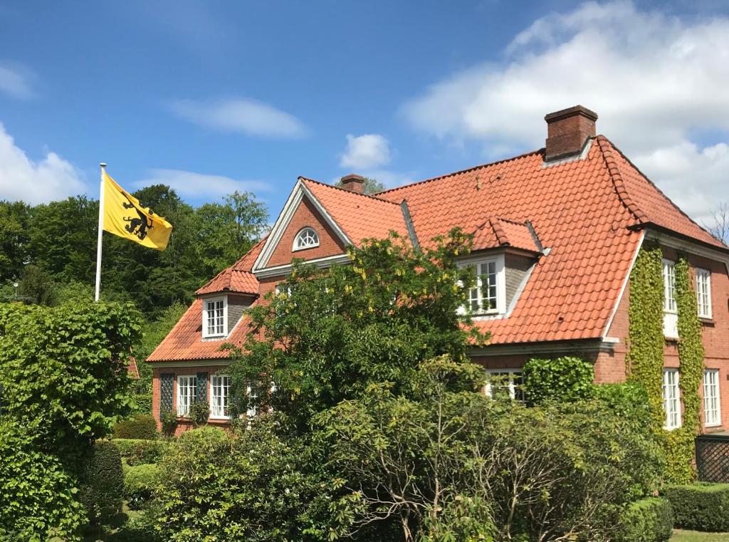 ein Haus mit gelber Flagge davor in der Unterkunft Ferienwohnung Country Garden - Naturpark Schlei in Güby