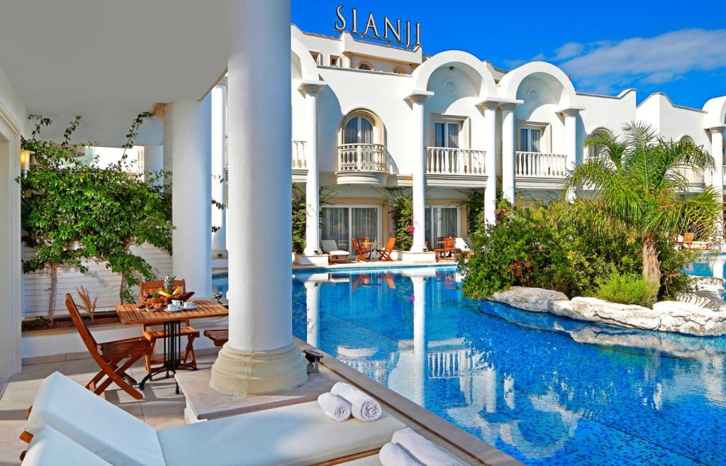 a hotel with a swimming pool and a resort at Sianji Well-Being Resort in Turgutreis