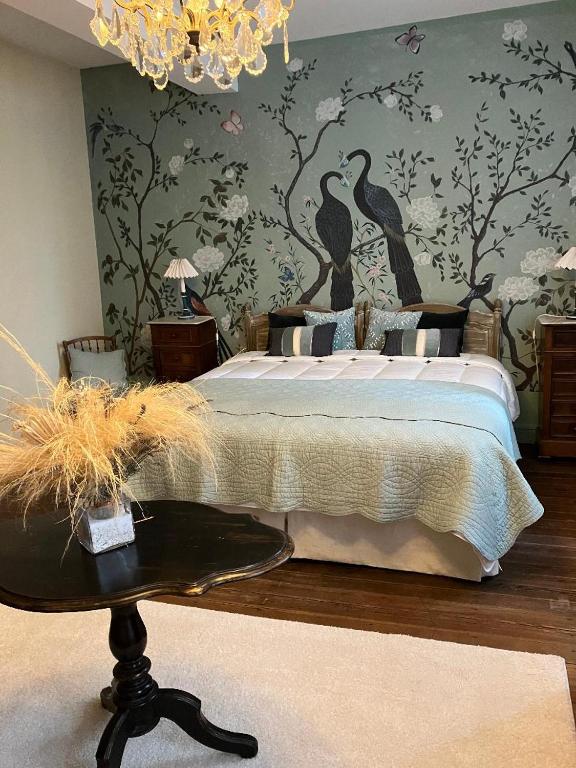 une chambre avec un lit et un lustre dans l'établissement Maison d'Hôtes Martineau, à Saint-Symphorien