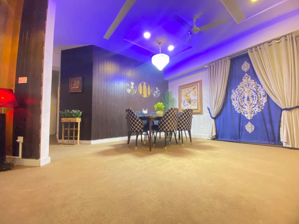 uma sala de jantar com mesa e cadeiras em Viceroy Royal Hotel Apartment Islamabad em Islamabad