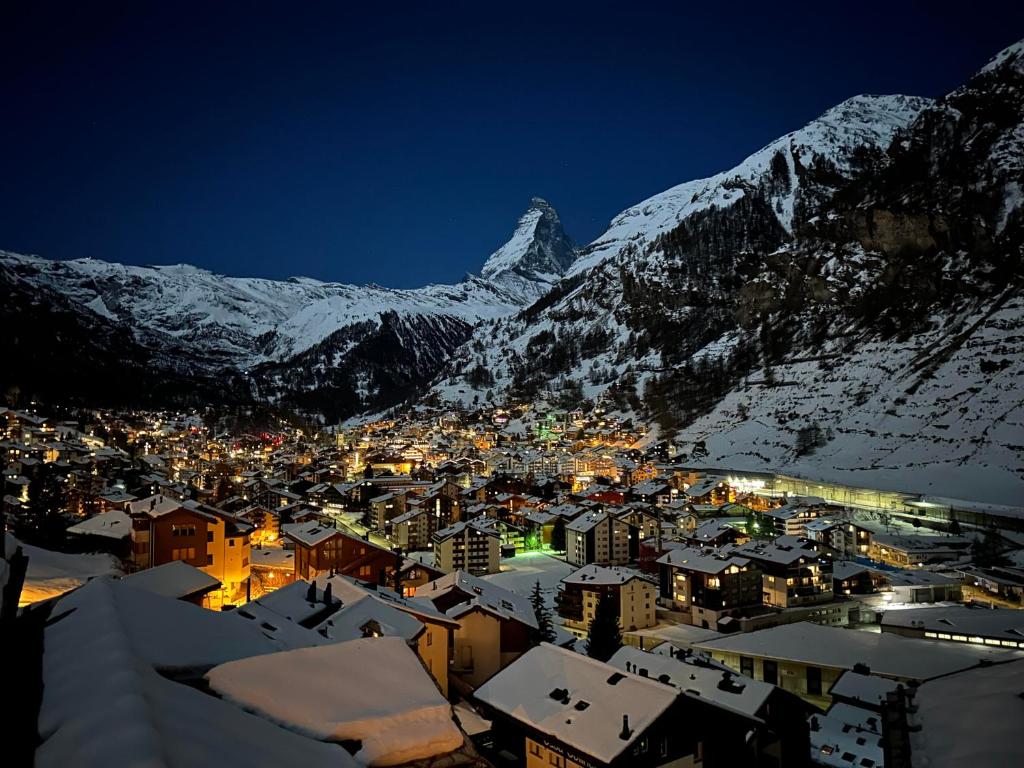 una ciudad con una montaña nevada en el fondo en Modern apartment with stunning village and Matterhorn views, en Zermatt