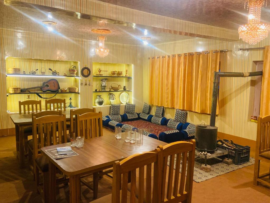 a dining room with a table and a couch at THE GULMARG PALACE in Gulmarg