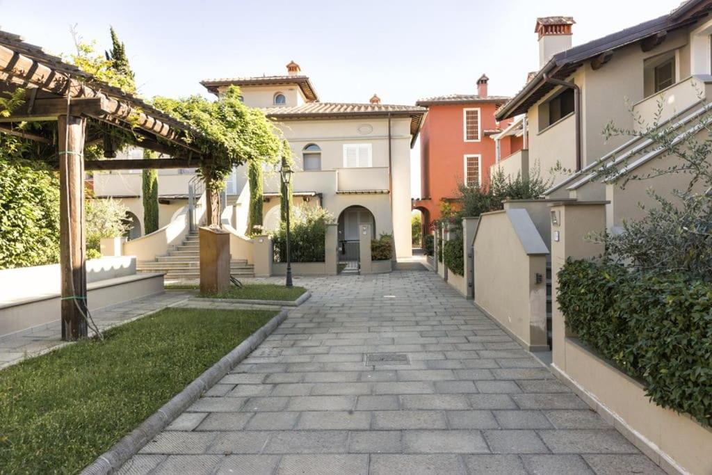 une passerelle dans une cour avec quelques bâtiments dans l'établissement Borgo24 family vacation Florence, à Lastra a Signa