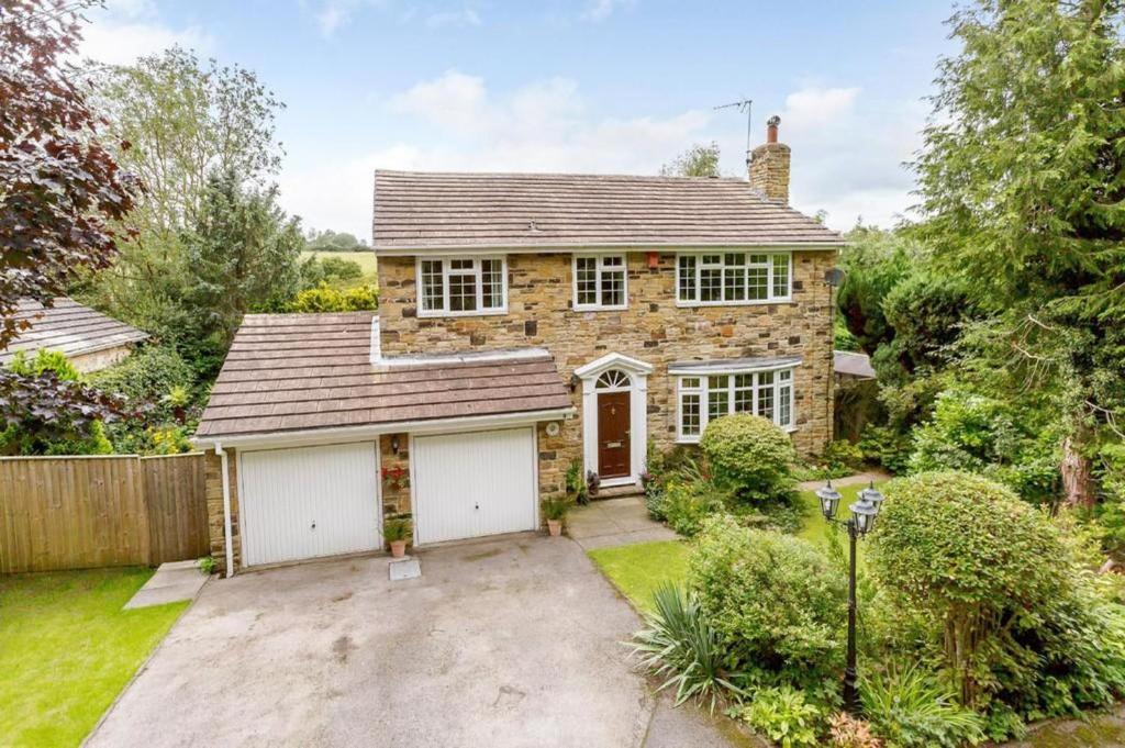 a brick house with a garage in a yard at Stunning 4-Bed House in Wetherby near York in Wetherby