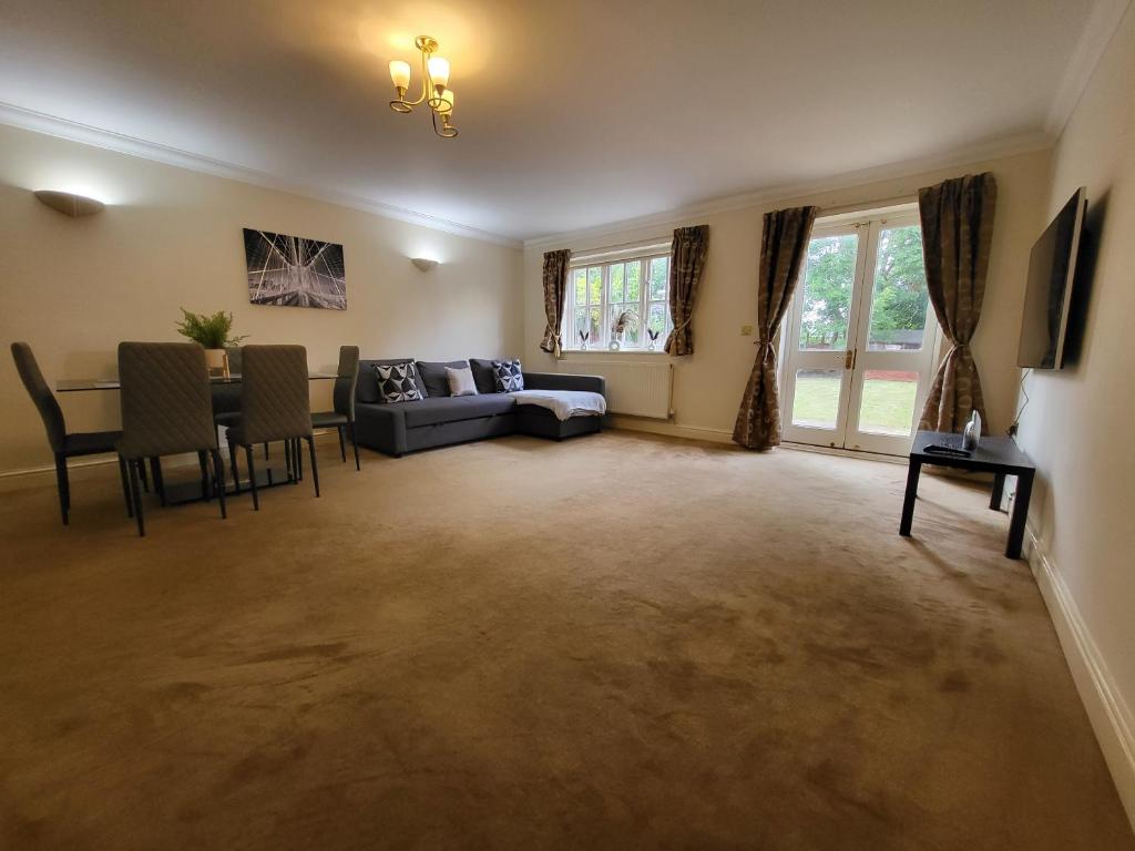 ein Wohnzimmer mit einem Sofa und einem Tisch in der Unterkunft Rare Contemporary 5 Bed London Home 7min - Station in Surbiton