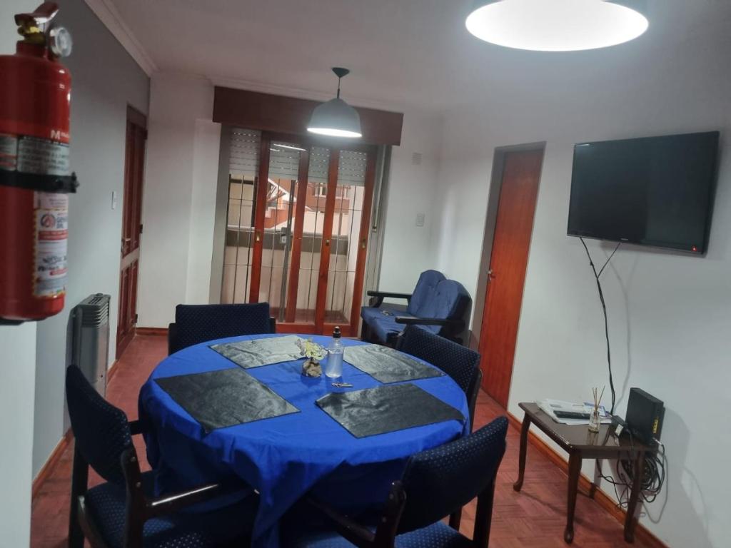 Habitación con mesa azul con sillas y TV. en Espacio Belgrano departamento centrico en Salta