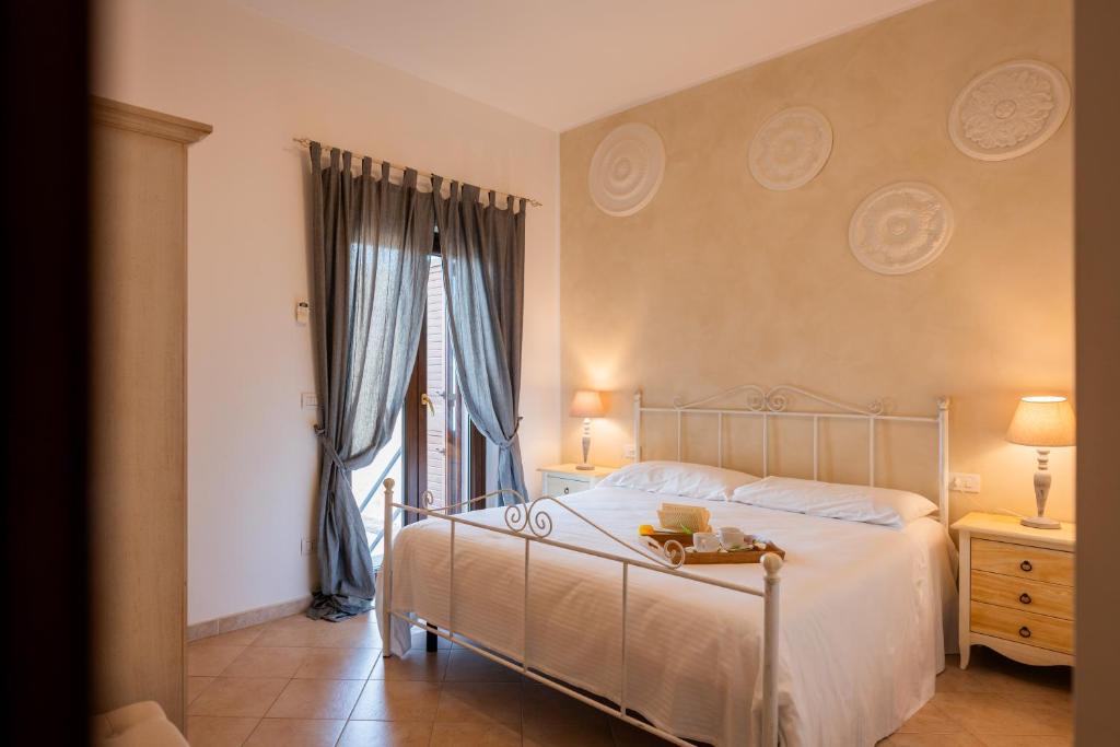 um quarto com uma cama branca e uma janela em Palazzo De Luca by Apulia Hospitality em Fasano