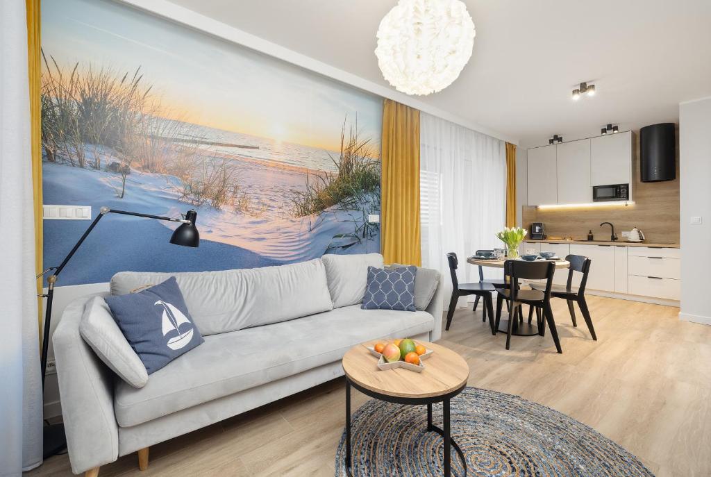 salon z kanapą i stołem w obiekcie Coast Apartment with Large, Furnished Balcony in Gąski by Renters w Gąskach