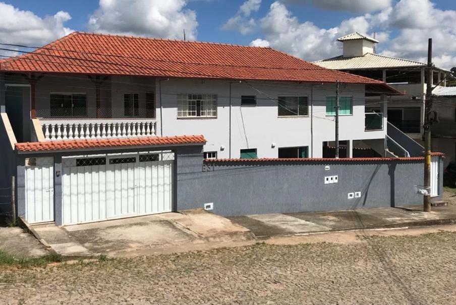 a white house with a red roof at Sinta-se em casa. in Barbacena