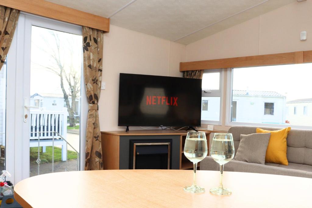 two wine glasses sitting on a table in a living room at 6-8 sleeper caravan Trecco Bay essentials included in Porthcawl