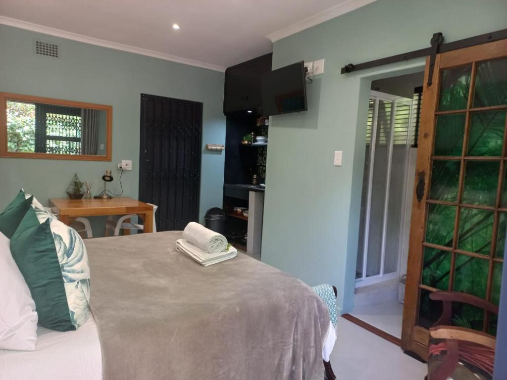 a bedroom with a bed and a table and a window at Lucano 1 Stellenbosch in Stellenbosch