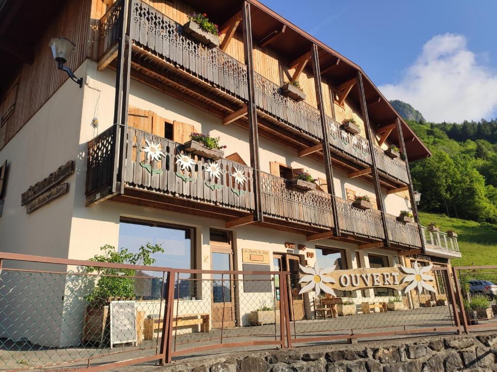 - un bâtiment avec des balcons, des tables et des chaises dans l'établissement Les Chemins du Léman, à Novel