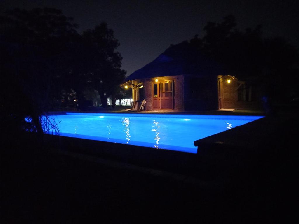 una piscina por la noche con luces azules en QuintaLasBoleadoras en General Rodríguez