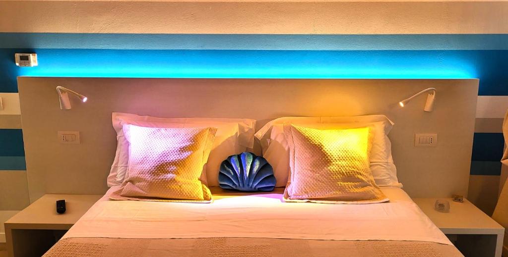 a bed with colorful pillows and a blue headboard at Stella del Garda in Lazise