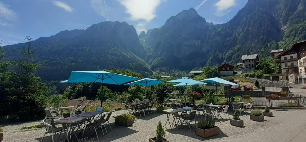 a group of tables and chairs with mountains in the background at Les Chemins du Léman in Novel
