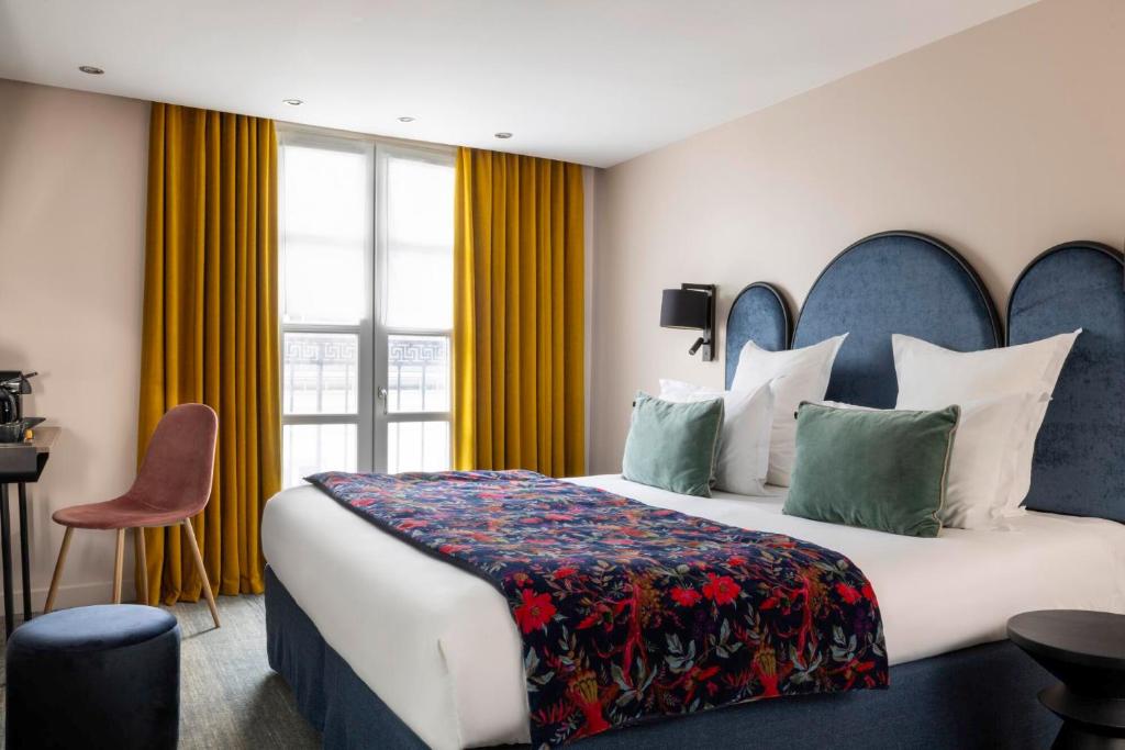 een hotelkamer met een groot bed en een raam bij Hôtel Maxim Opéra in Parijs