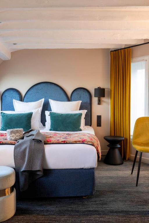 une chambre avec un grand lit avec une tête de lit bleue dans l'établissement Hôtel Maxim Opéra, à Paris
