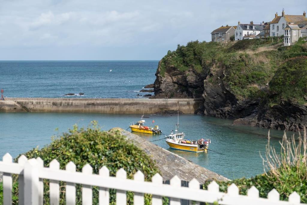 two boats in a body of water with a white fence at White House, Port Isaac Bay Holidays in Port Isaac