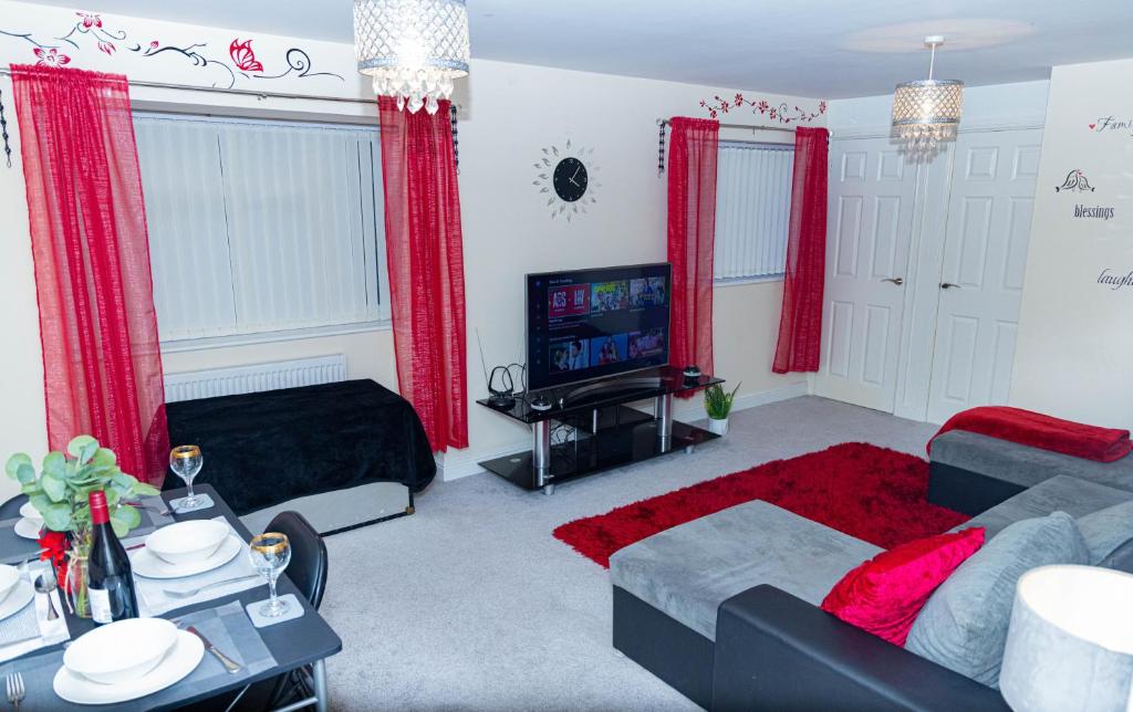 a living room with red curtains and a tv at 2ndHomeStays-West Bromwich- A Charming 2-Bedroom Maisonette in West-Midlands, Suitable for long Stay Contractors-Families-Group of Friends on Holiday, 10 mins to J1 M5 and 24 mins to Birmingham in West Bromwich
