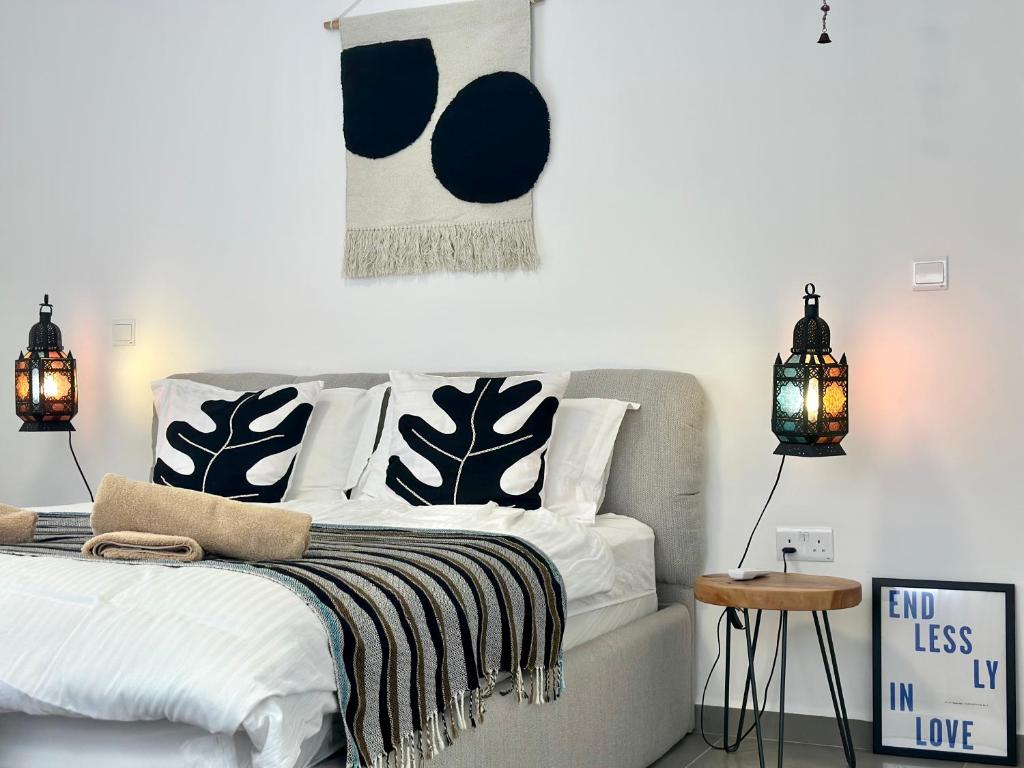 une chambre avec un lit avec des oreillers noirs et blancs dans l'établissement Premium HOME: Bungalow-Apartment mit Rooftop nahe Golfclub & SPA, à Ayios Yeoryios