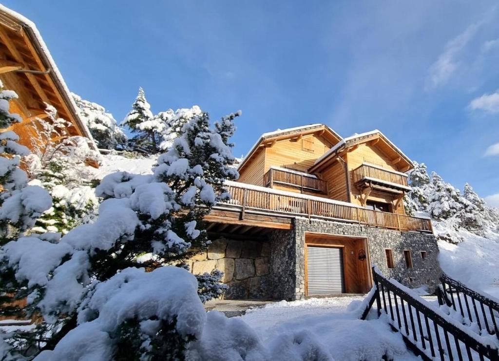 una casa en la nieve con árboles nevados en Luxueux chalet avec terrasse Auron, en Saint-Étienne-de-Tinée
