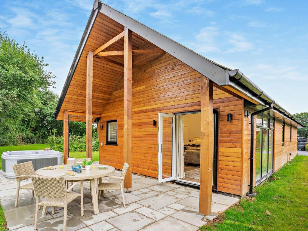 uma pequena casa de madeira com uma mesa e cadeiras em 3 bed property in Gower South Wales 91727 