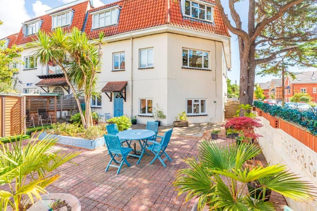 a patio with a table and chairs in front of a house at Bournecoast: Patio Garden - Parking - WIFI -FM8455 in Bournemouth