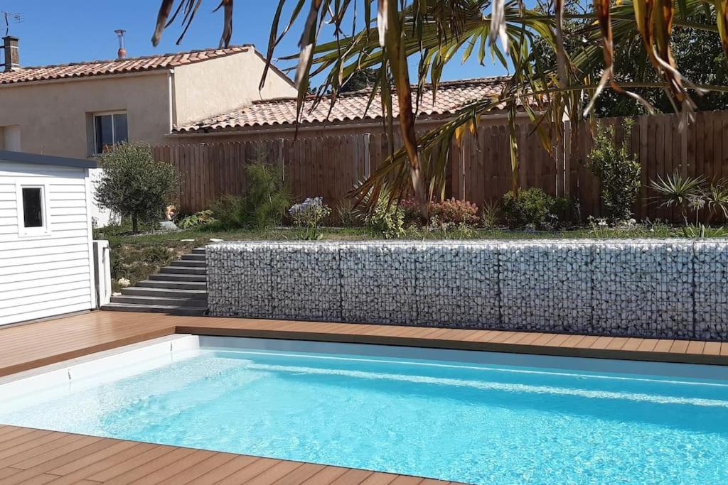 een zwembad voor een huis met een hek bij Élégante maison avec piscine in Saint-Vincent-sur-Jard