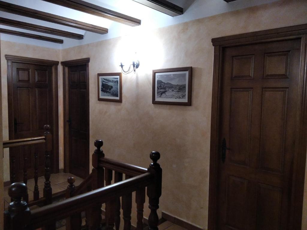 pasillo con escalera y puerta de madera en Casa la Cisterna, en Pina de Montolgrao