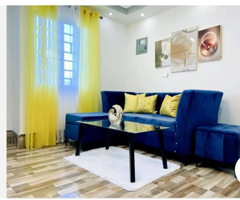 a living room with a blue couch and a table at JC caribe Aparta Hotel #7 in Boca Chica