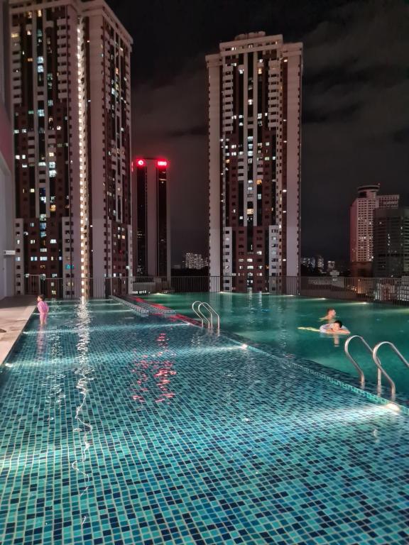 吉隆坡的住宿－Chambers Suites KLCC by Moonlight，游泳池在城市顶端的夜晚