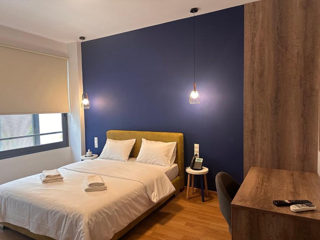 een slaapkamer met een groot bed met een blauwe muur bij Luxury Suites Athens 2 in Athene