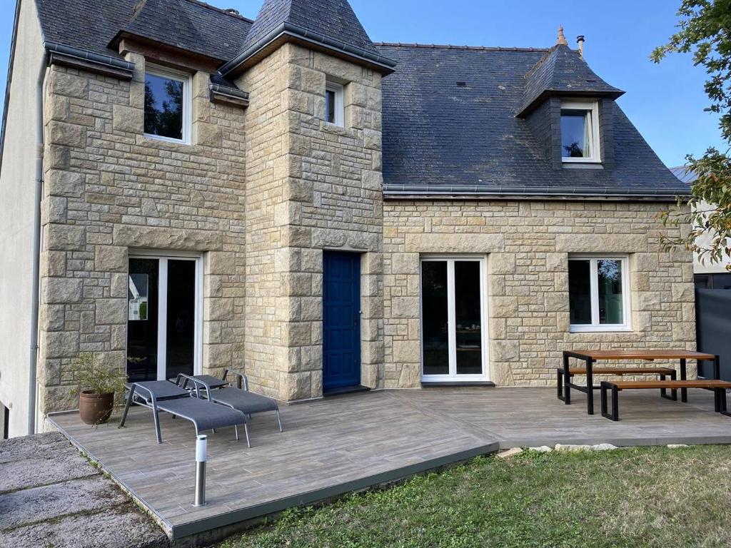 Cette maison en pierre dispose d'une terrasse et d'une porte bleue. dans l'établissement 209 - Charmante maison entièrement rénovée à quelques pas de Sables-Dor-Les-Pins, à Plurien