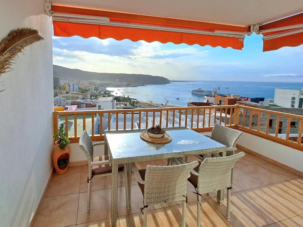 una mesa en un balcón con vistas al océano en Apartment Cactus II Los Cristianos, en Los Cristianos