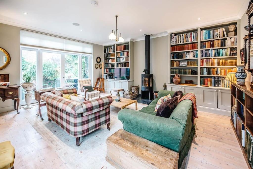 ein Wohnzimmer mit 2 Sofas und Bücherregalen in der Unterkunft 29 Wentworth Road, Aldeburgh in Aldeburgh