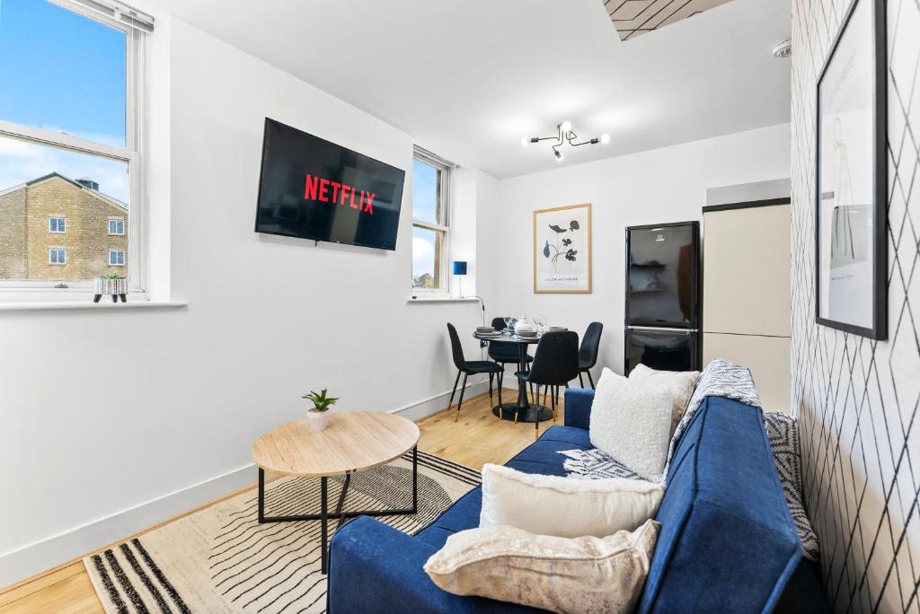 a living room with a blue couch and a table at Lovely Yorkshire Duplex - Sleeps 6 - Netflix in Dewsbury