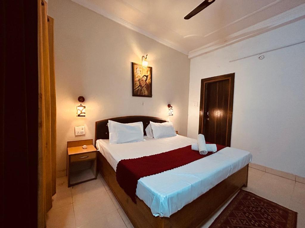 Hotel 4 You - Top Rated and Most Awarded Property In Rishikesh في ريشيكيش: غرفة نوم بسرير كبير مع بطانية حمراء
