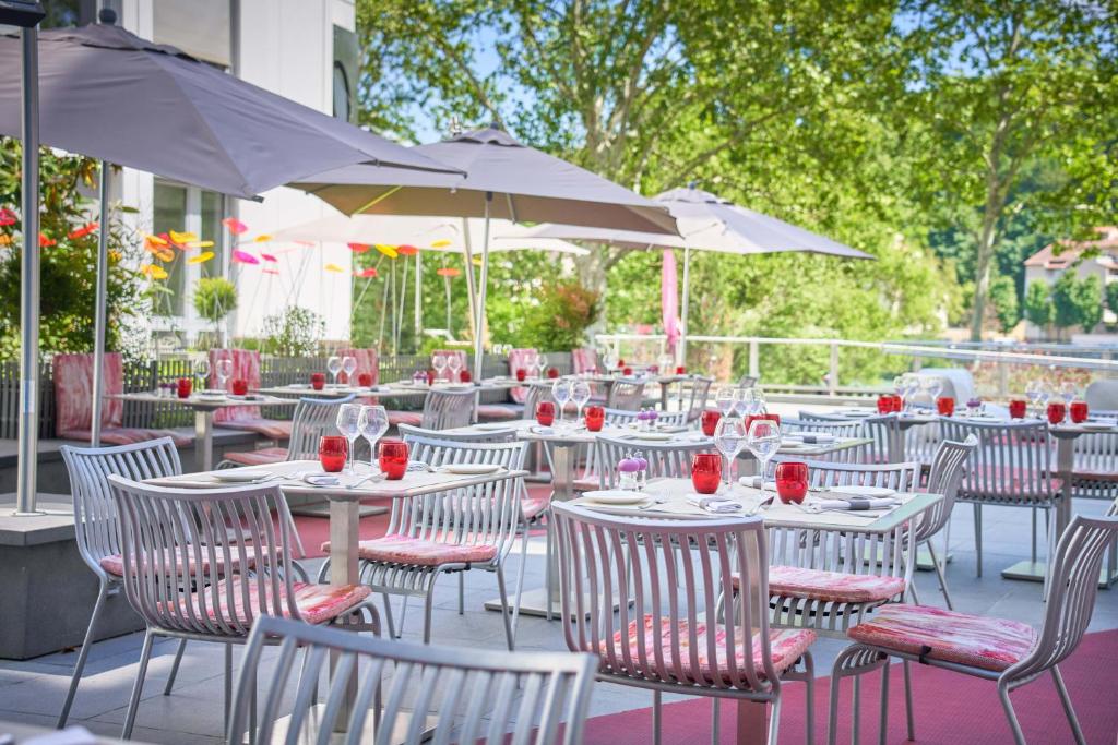 um grupo de mesas e cadeiras com copos de vinho em Hotel Lyon-ouest em Lyon