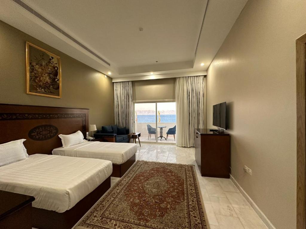 Al Humaizah的住宿－Vista Haql Hotel，酒店客房设有两张床和电视。