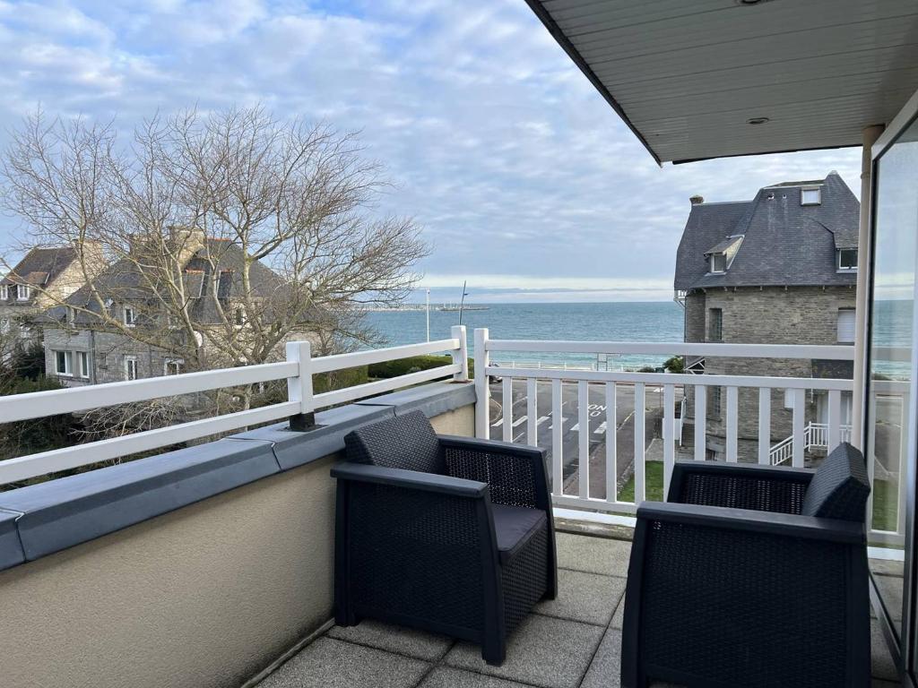 Un balcón con dos sillas y vista al mar. en 390 Appartement 3 chambres avec vue sur la Grande Plage de Saint-Cast, en La Garde