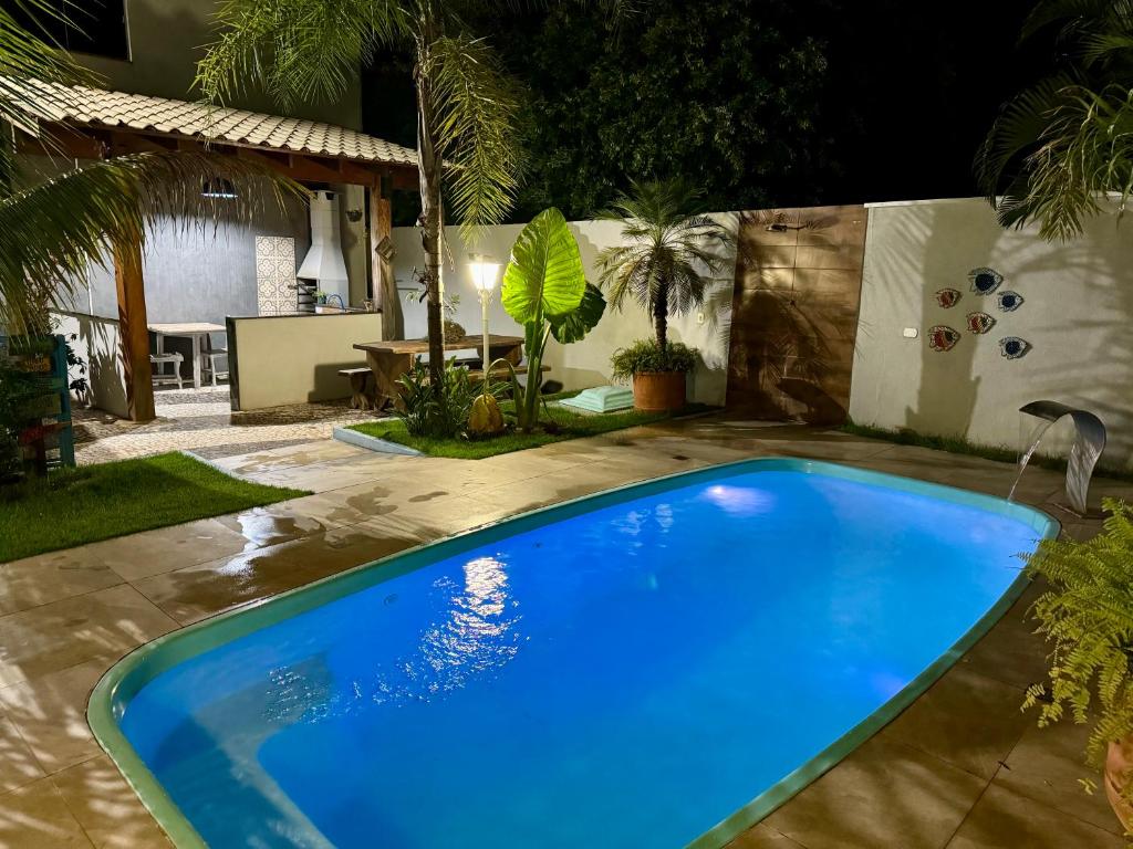 a blue swimming pool in a backyard at night at Cambará Suítes in Bonito
