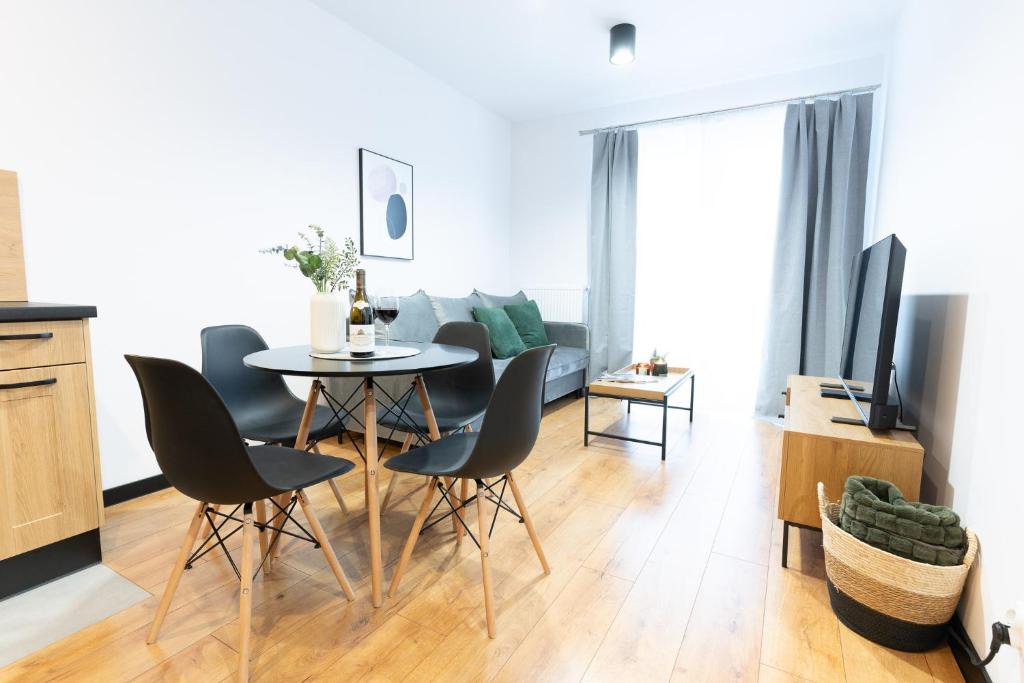 cocina y sala de estar con mesa y sillas en River Song Apartment, en Nowe Miasto Lubawskie