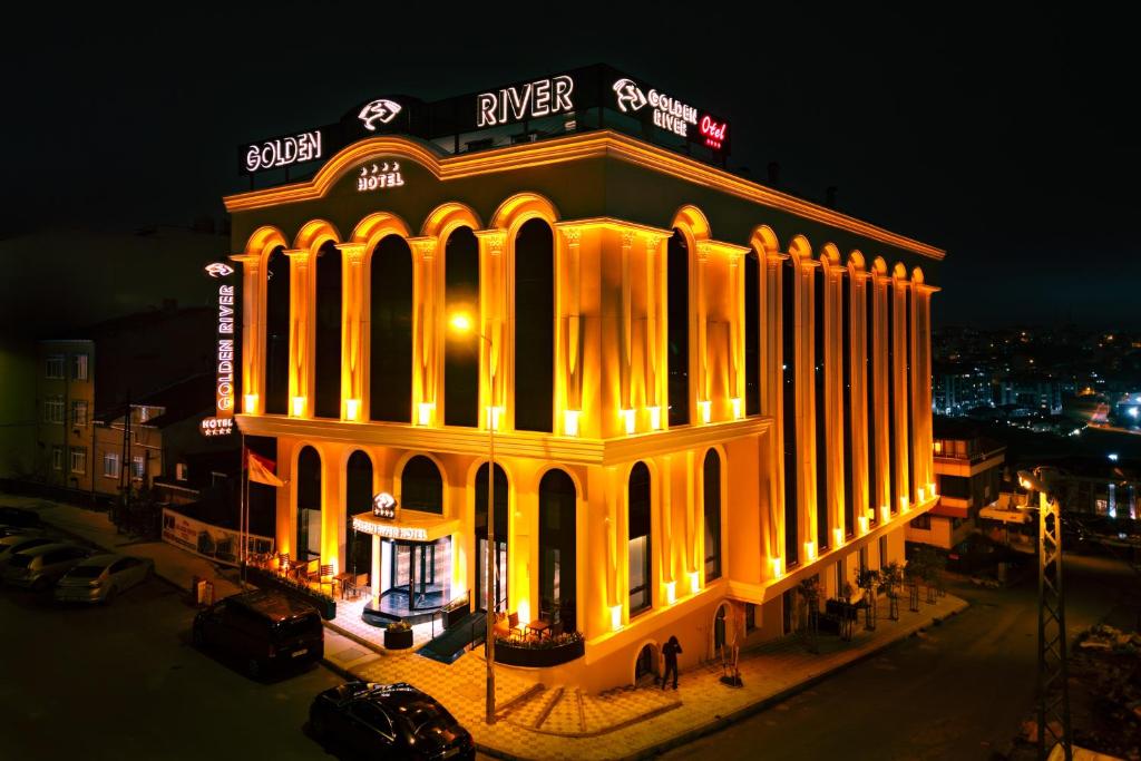 a building lit up at night with lights at Golden River Hotel By Continent in Arnavutköy