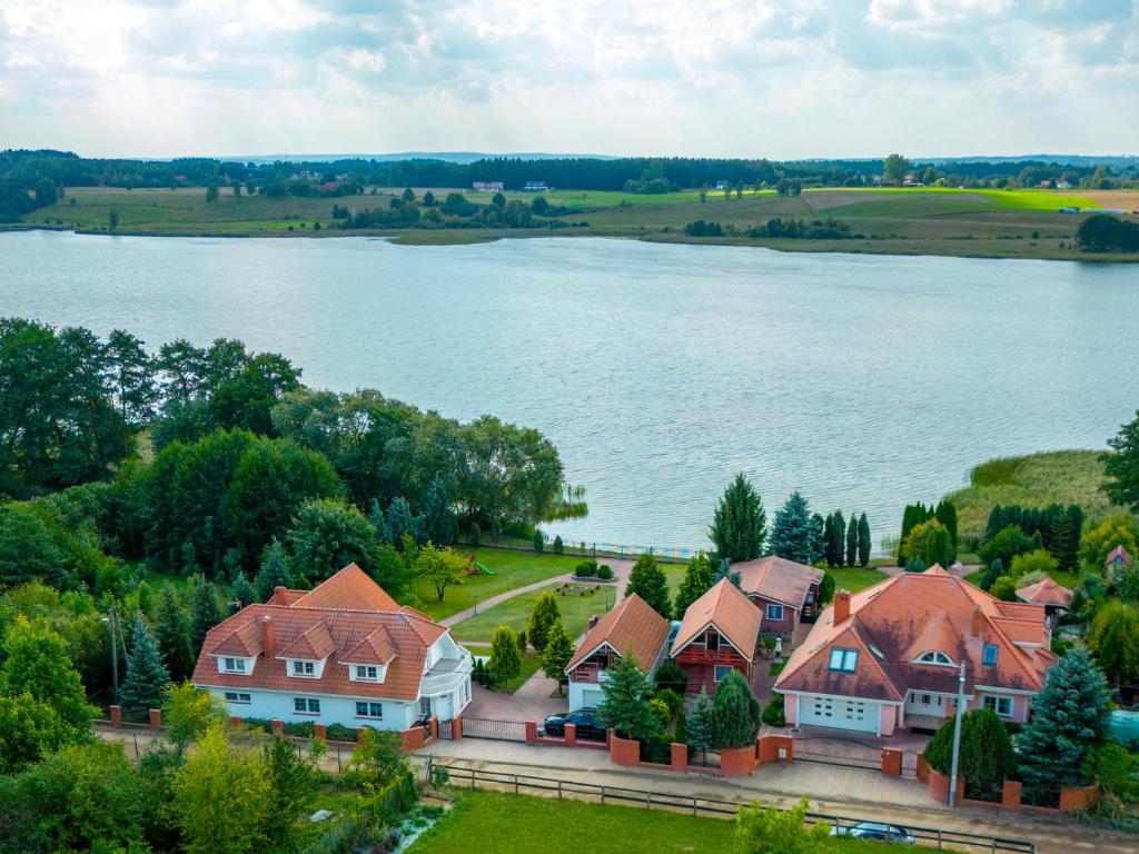 an aerial view of a house next to a lake at Domki Kątno in Stare Jabłonki