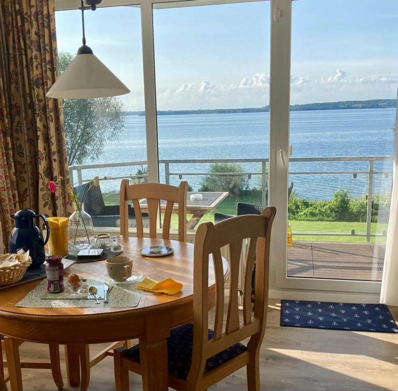 a dining room table with a view of the ocean at Ferienwohnung Plöner See in Ascheberg