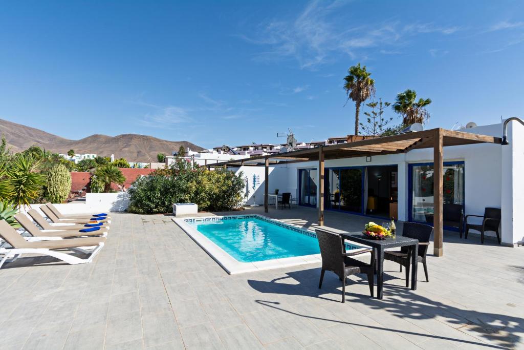a patio with a table and chairs and a swimming pool at Villa Cangrejita Private Pool Playa Blanca By PVL in Playa Blanca