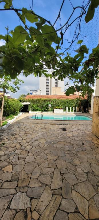 une cour en pierre avec une piscine et un bâtiment dans l'établissement Recanto Azul, à Aparecida