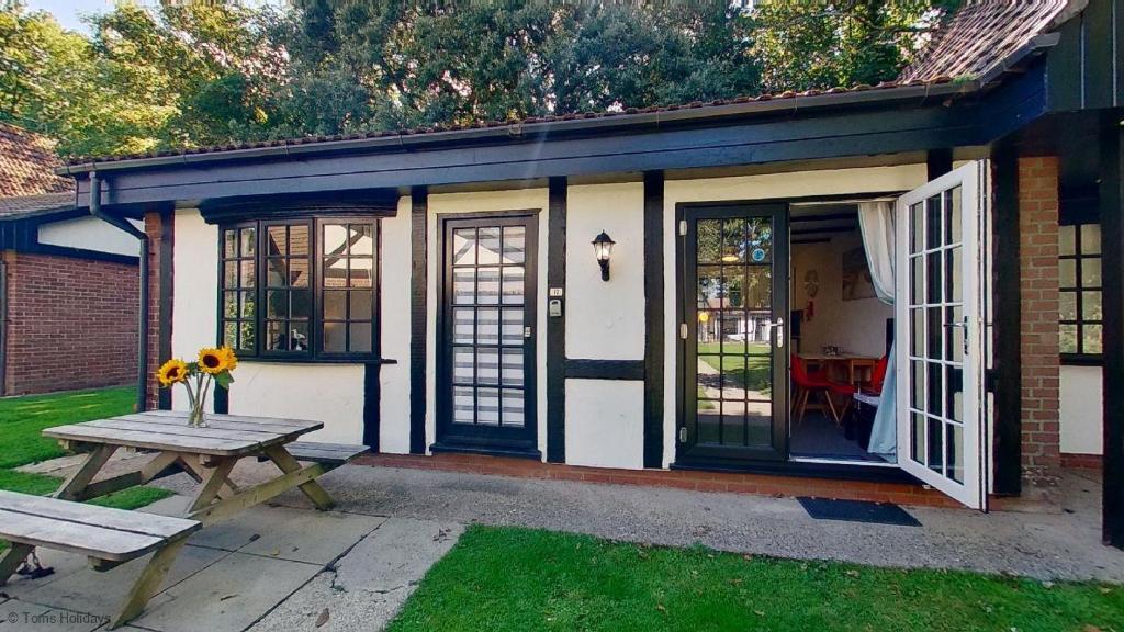 a small house with a picnic table and a bench at 12 Tudor Court, Tolroy Manor in Hayle