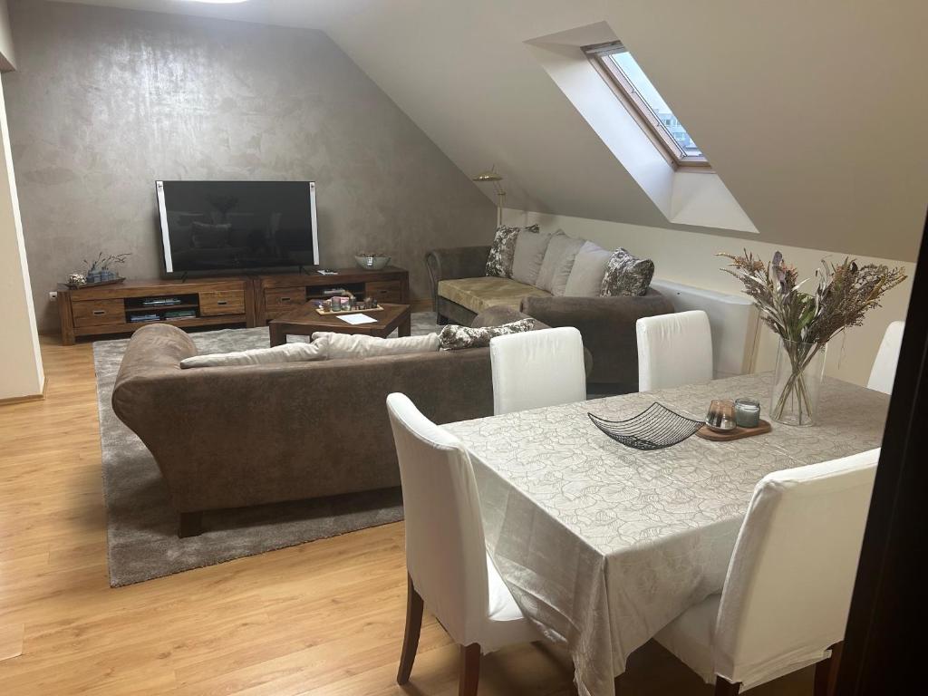 een woonkamer met een bank en een tafel met een televisie bij Apartmán 301 VOLT in Nové Zámky