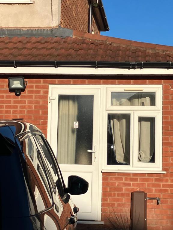 a white door on the side of a brick house at Dream private ensuite apartment in Solihull close to Birmingham airport-city centre and NEC in Birmingham